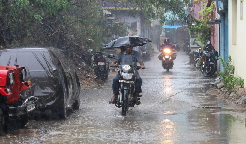 Chennai: A man on a motorbike holds an umbrella ride past during heavy rain in Chennai on Tuesday
