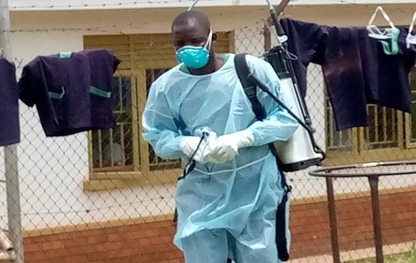 Medical workers perform disinfection for a demarcated Ebola treatment center at the Mubende Regional Hospital