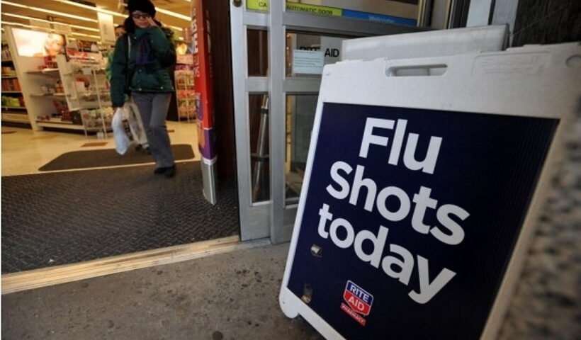 A sign advertising the availability of flu shots is put outside a CVS pharmacy store in New York, the United States.