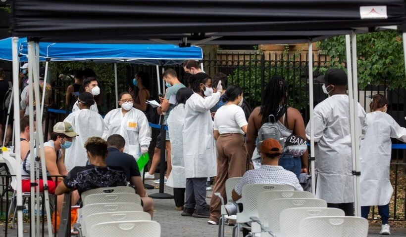 Health care workers assist people waiting to be vaccinated at a monkeypox vaccination site in New York,