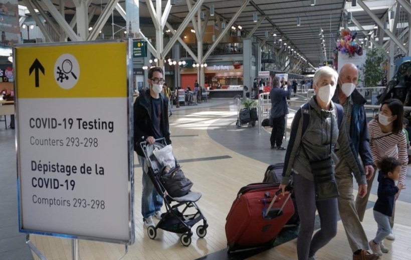 Travelers with face masks are seen at Vancouver International Airport in Richmond, Canada,