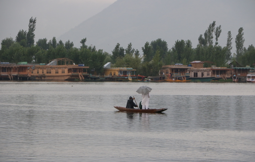 Srinagar: A man enjoys boat ride in the Dal Lake amidst rains in Srinagar