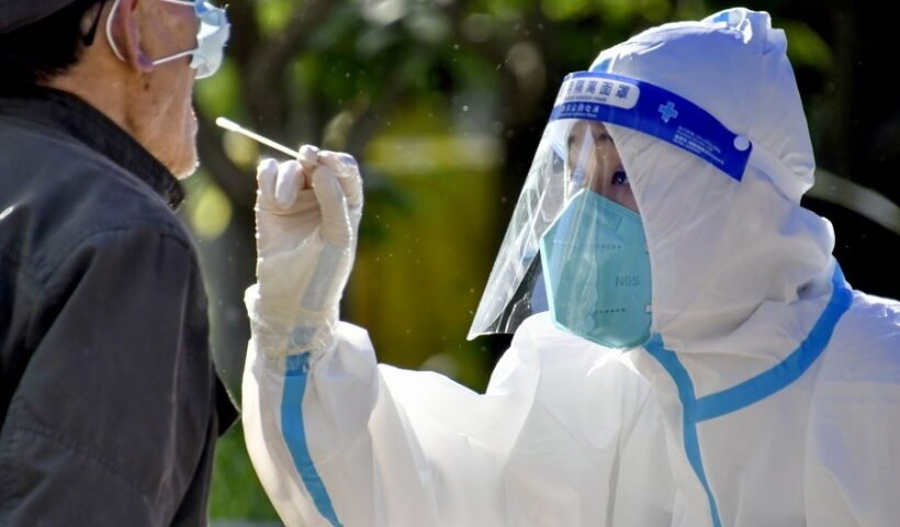 1390297 Caption: A medical worker takes a swab sample from a citizen for nucleic acid testing in Chaoyang