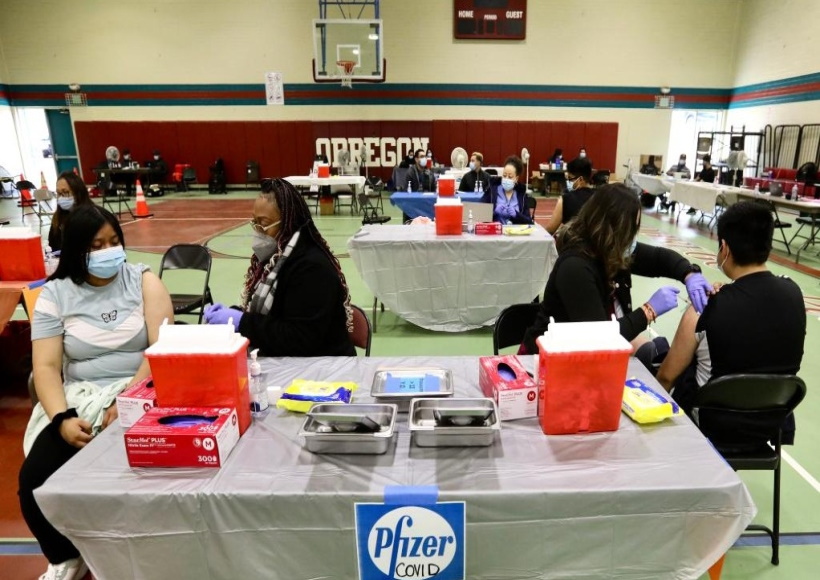 Health workers administer COVID-19 vaccine shots to local residents in Los Angeles, the United States