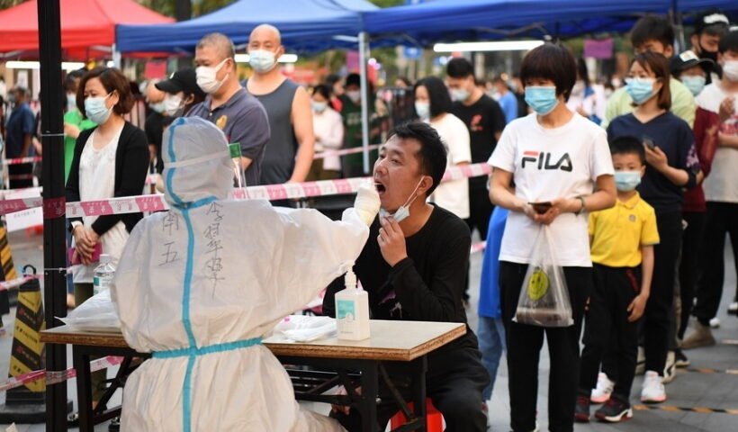 A medical worker takes a swab sample from a resident for nucleic acid test at a community in Liwan District of Guangzhou