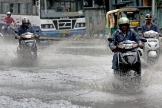Vehicles wade through waterlogged road in Bengaluru