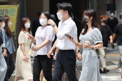 People walk along the street while voluntarily wearing masks