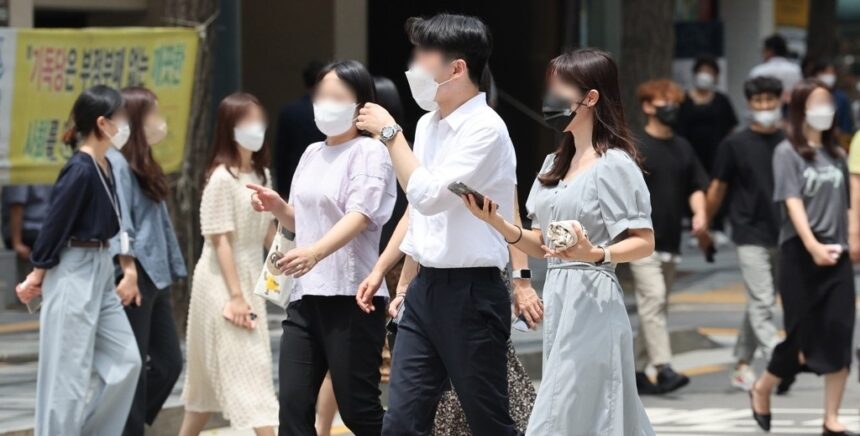 People walk along the street while voluntarily wearing masks