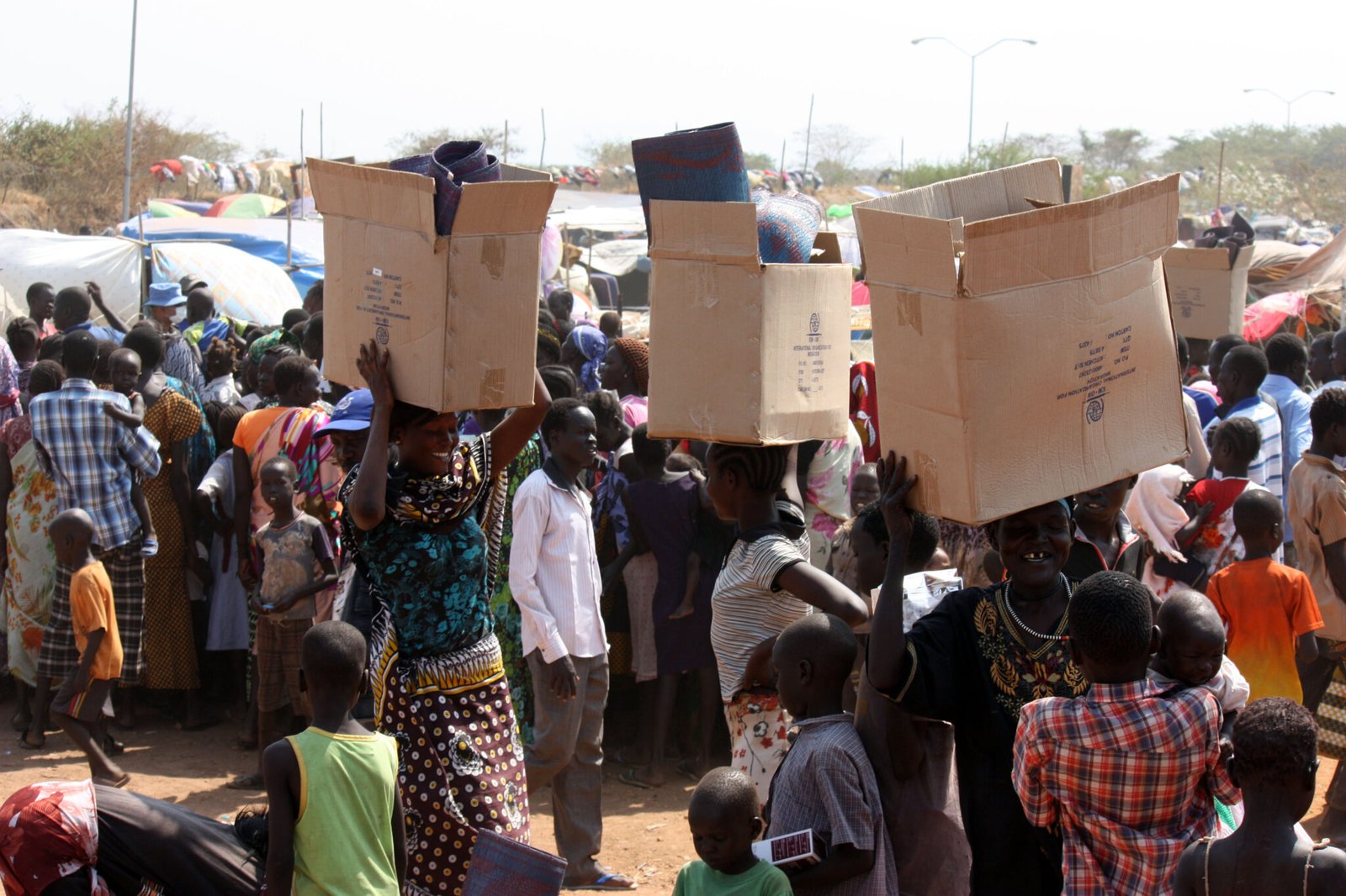 South Sudanese refugees carry relief materials in a UN camp in Juba