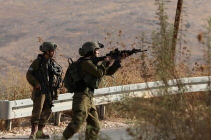 Israeli soldiers close a road after a shooting attack on an Israeli bus