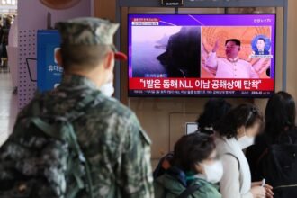 A soldier watches a TV report at Seoul Station