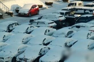 Cars are covered with snow at an apartment complex in Wonju