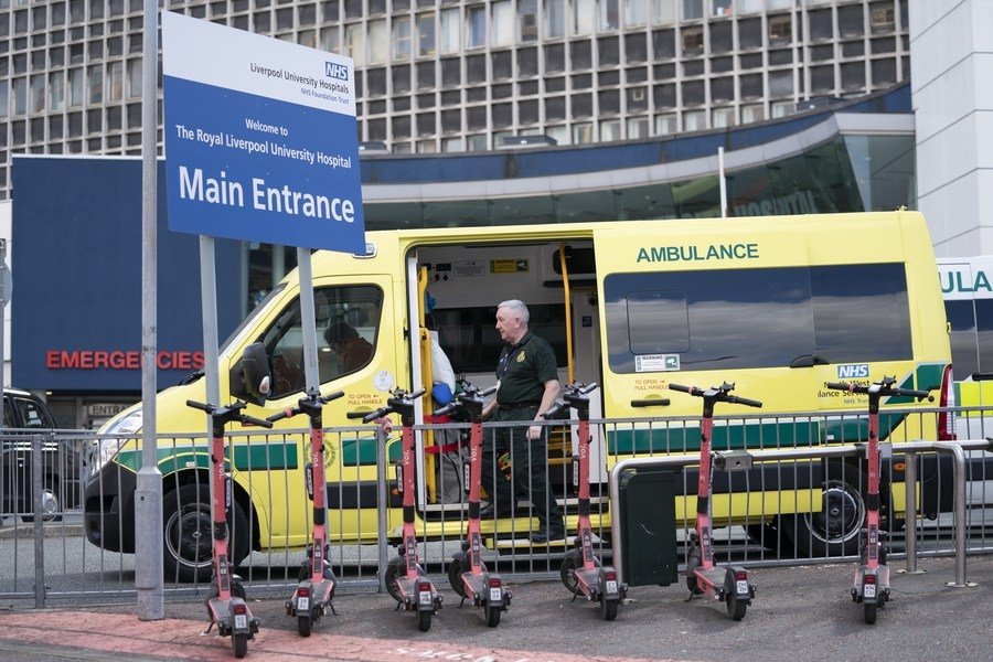 A staff member stands next to an ambulance outside the Royal Liverpool University Hospital in Liverpool
