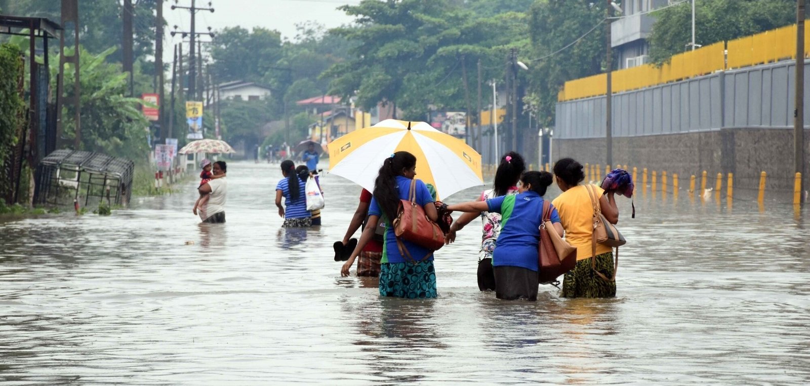 People wade through water in suburban areas of Colombo