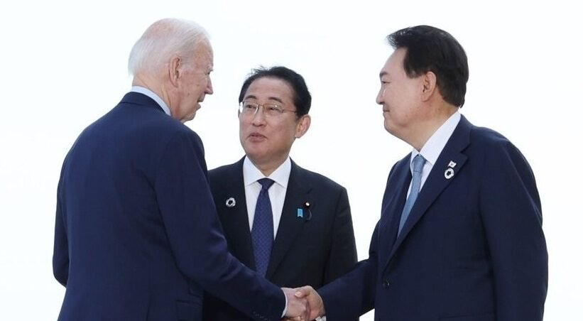 South Korean President Yoon Suk Yeol (R) speaks with U.S. President Joe Biden (L) and Japanese Prime Minister Fumio Kishida