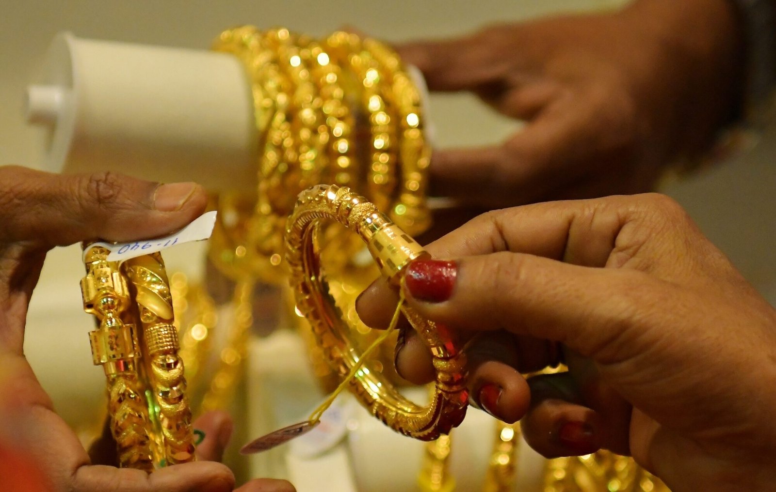 Women select gold jewellery at a showroom