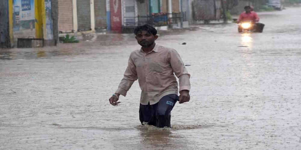 A man walks through a waterlogged road